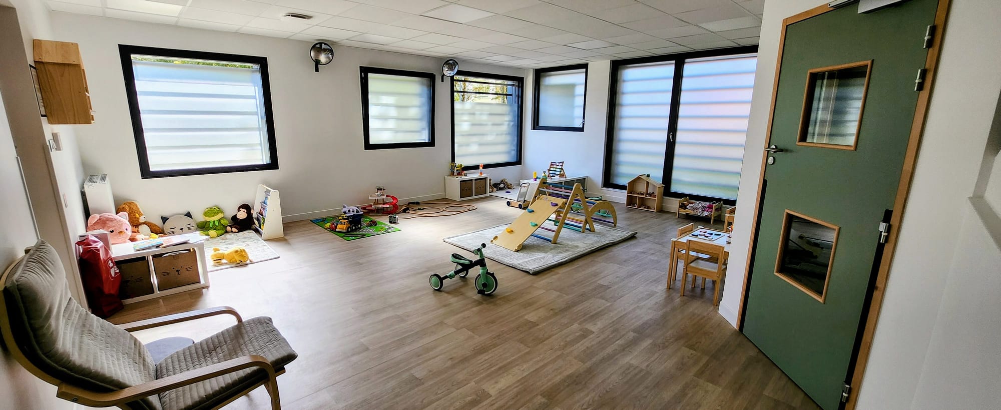 Salle de vie lumineuse de la micro-cr&egrave;che ASA BABY &agrave; Poissy, avec espace de motricit&eacute;, coin lecture et jeux en bois