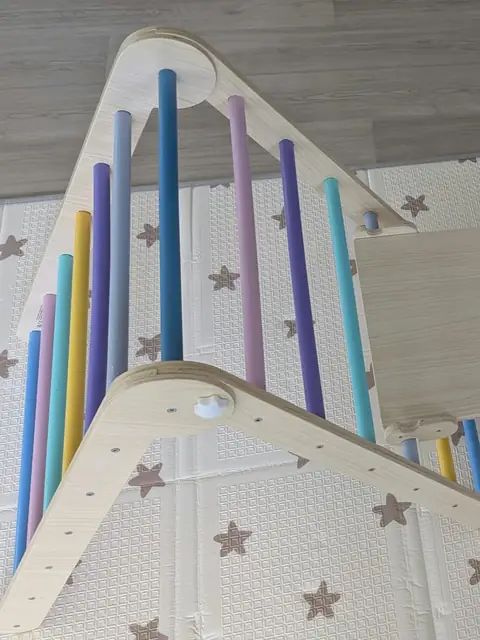 Structure de motricit&eacute; en bois avec barreaux color&eacute;s et planche inclin&eacute;e